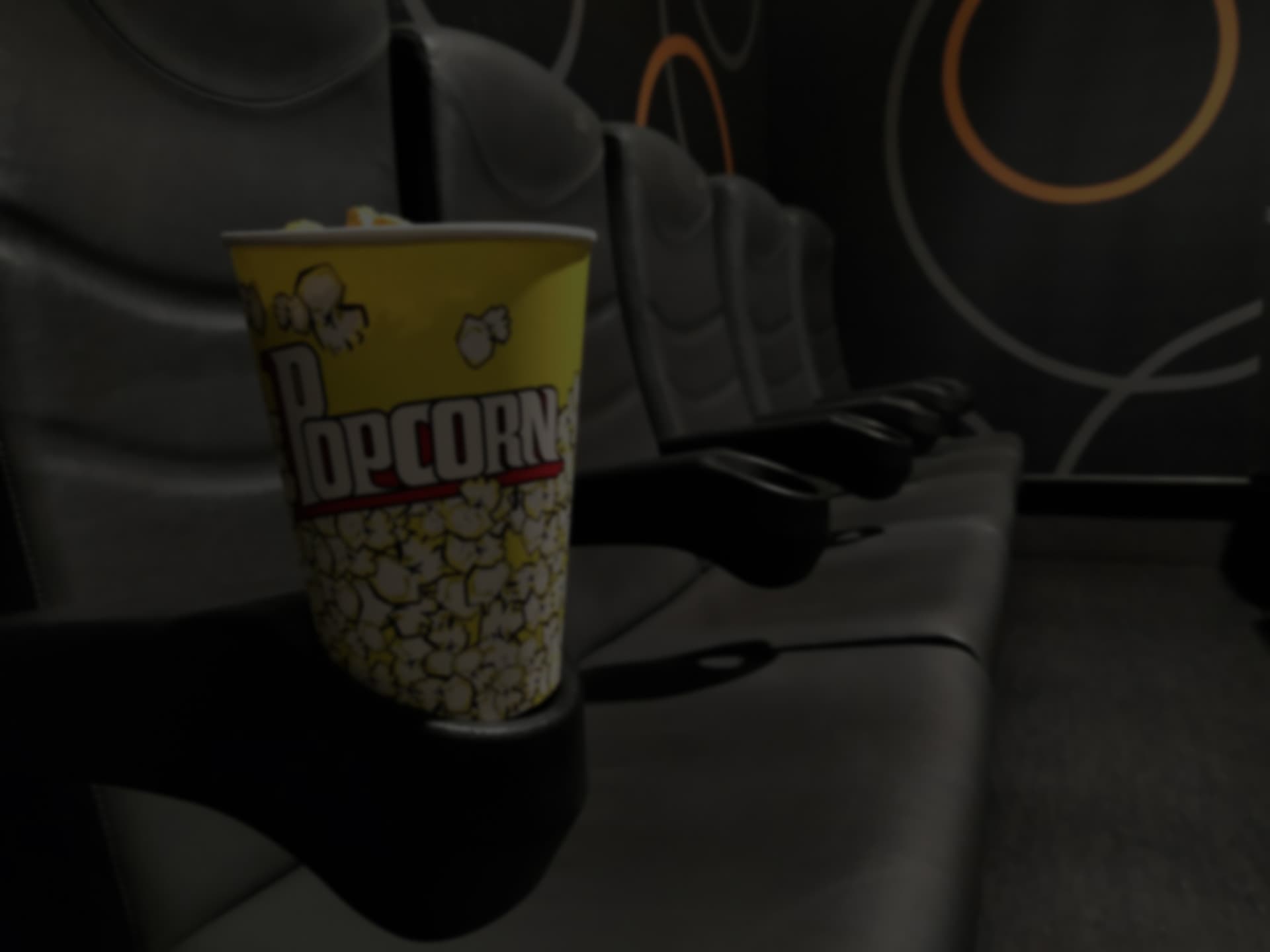 Popcorn-Becher im Halter eines Kinosessels